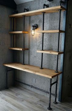 an industrial shelving unit with wooden shelves and metal pipes on the wall, along with a light fixture