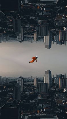 an orange object floating in the air over a cityscape with tall buildings and skyscrapers