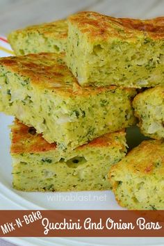 several pieces of broccoli and onion bars stacked on top of each other in a white plate