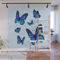 blue butterflies on a wall in a room with wooden flooring and ladders to the side