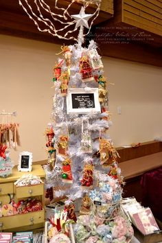 a white christmas tree sitting on top of a table next to other items and decorations