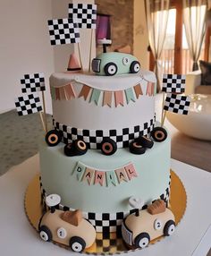 a three tiered cake decorated with cars and bunting flags for a race themed birthday party