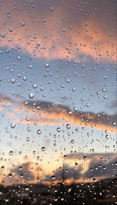 rain drops on the window as the sun sets