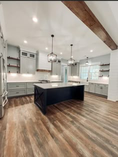 an empty kitchen with wooden floors and gray cabinets