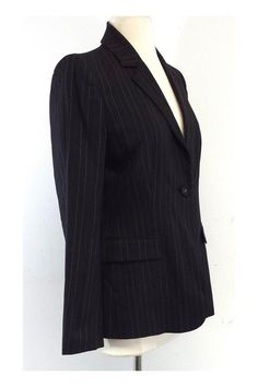 Size 4 Black Pinstripe Blazer Shell 67% wool 29% viscose 3% spandex 1% polyester Lining 100% polyester Padded shoulders Single front button close 2 front decorative flapover pockets White & black polka dot lining Shoulder to shoulder 15" Shoulder to hem 26" Elegant Striped Outerwear For Office, Fitted Striped Wool Outerwear, Tailored Striped Outerwear For Office, Classic Striped Blazer For Office, Classic Striped Outerwear For Office Wear, Classic Fitted Striped Outerwear, Fitted Striped Blazer For Business Casual, Striped Fitted Outerwear For Business Casual, Minimalist Fashion Casual