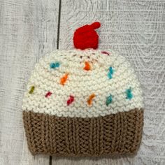 a crocheted cupcake hat on top of a wooden table