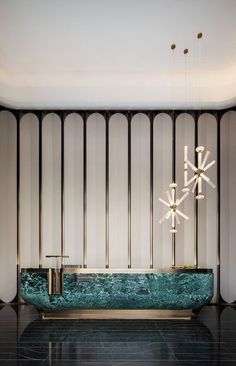 an elegant bathroom with black marble and gold accents, including chandelier above the bathtub