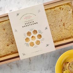 a box of honeycombs next to a yellow plate with a piece of bread on it