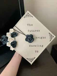 a hand holding a graduation cap with flowers on it that says the future is bright dazzleling us