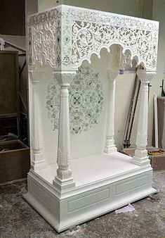 a white gazebo sitting on top of a floor next to a box filled with boxes