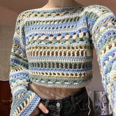 a mannequin wearing a crocheted sweater and jeans