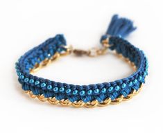 a blue bracelet with gold chains and tassels