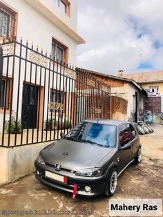 a grey car parked in front of a building