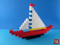 a lego sailboat made out of white and red bricks on a blue background,