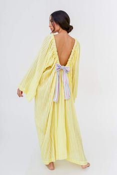 The maxi-length Open Back Bow Dress is made with our soft and delicate cotton gauze fabric, featuring long bell sleeves and an adjustable open back tied with a thick rainbow ribbon. Spring Maxi Dress With Back Tassel Tie-up, Spring Dresses With Back Tassel Tie-up, Spring Midi Dress With Ruffles And Balloon Sleeves, Billowy Maxi Dress With Smocked Back, Billowy Smocked Back Maxi Dress For Daywear, Billowy Smocked Back Dress For Vacation, Spring Balloon Sleeve Dress Down Dresses, Billowy Maxi Dress With Smocked Back For Daywear, Spring Dresses With Balloon Sleeves For Dress Down Occasions