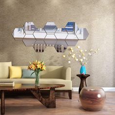 a living room filled with furniture next to a wall mounted shelf above a coffee table