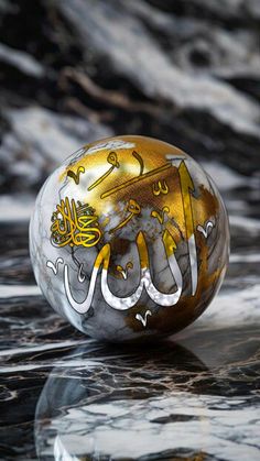 a marble ball with arabic writing on it sitting on top of a black and white table