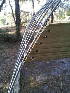 there are many wires attached to the side of a wooden structure in front of some trees