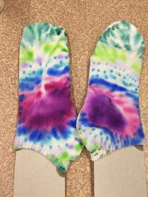 a pair of colorful tie - dyed mitts sitting on top of a carpeted floor