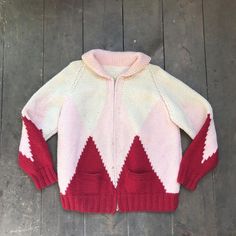 C1960s Hand Knit Ski / Skate Wool Sweater- 100% Wool- Off white coloured with pink and red ski/skate like pattern- Nice, thick and long collar-  zipper- Two small front pockets- Broad shoulders- Fits like a womans medium / large ( please refer to measurements for precise size)Measurements taken with sweater lying flat:Length: 26"Width: 22"Sleeve length: 17"In good, vintage condition showing some light marks ( see all pics on #10)  And overall wear and age White Retro Winter Cardigan, Pink Long Sleeve Retro Cardigan, Pink Wool Knitted Sweater, White Retro Knitted Sweater, Fitted Pink Wool Sweater, Pink Fitted Wool Sweater, Vintage Pink Winter Cardigan, Pink Vintage Winter Cardigan, Retro Pink Long Sleeve Sweater