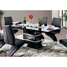 a glass dining table with black chairs and white rugs in front of a window