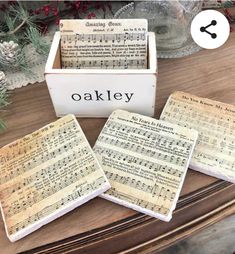 three coasters with sheet music on them sitting on a table next to a christmas tree