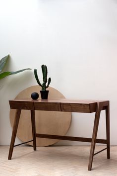 a wooden table sitting next to a potted plant