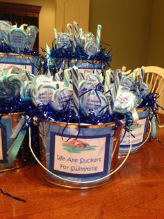 two buckets filled with blue and white candy sitting on top of a wooden table