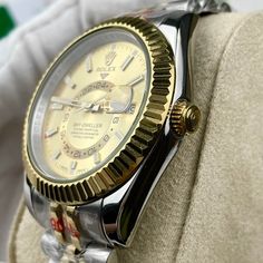 This timepiece is a Rolex Sky-Dweller, distinguished by its two-tone Oystersteel and 18ct yellow gold construction. The champagne dial features the iconic off-center 24-hour disc for dual time zone display, and an annual calendar. The watch is powered by the Calibre 9001, a complex self-winding mechanical movement. The fluted bezel, Oyster bracelet with Easylink extension, and Superlative Chronometer certification exemplify Rolex's commitment to precision and luxury. This Sky-Dweller is a sophis Luxury Silver Watch Accessories With Day-date Display, Gold Chronometer Watch Accessories With Round Dial, Gold Chronometer Watch With Round Dial, Elegant Silver Watch Accessories With Day-date Display, Formal Yellow Watches, Yellow Gold Watches With Day-date Display, Formal Yellow Watch With Chronometer, Classic Yellow Watch Accessories For Formal Occasions, Classic Yellow Chronometer Watch