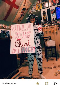 a person in a costume holding a sign that says will u be my chick at hog?