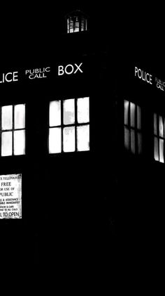 the police box is lit up in the dark with windows on each side and signs above it