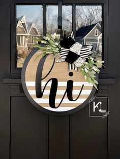 the front door is decorated with a monogrammed wreath