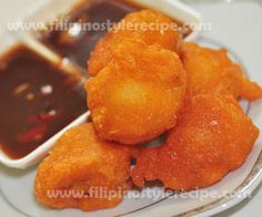 some fried food is on a plate with dipping sauce in the backgroung