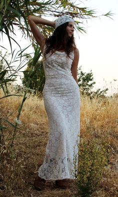 a woman in a white dress is posing for the camera with her hands on her head