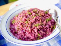 a white bowl filled with red cabbage on top of a blue and white checkered table cloth