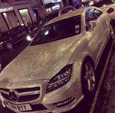 a silver car is parked on the side of the street with glitter all over it