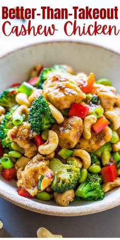 a bowl filled with cashew chicken and broccoli on top of a table