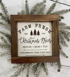 a wooden frame with christmas trees on it and the words farm fresh written in black