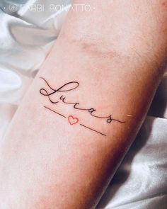 a woman's arm with a tattoo that says love on it and hearts in cursive writing