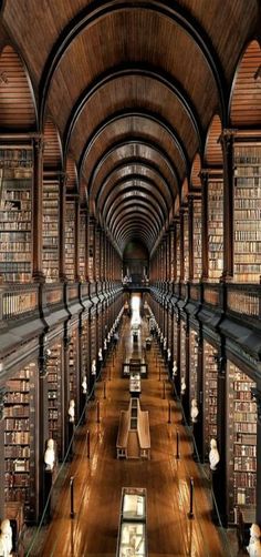 an old library with many bookshelves and benches lined up against the wall,