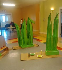 some fake green plants are sitting on the floor in a room with yellow walls and floors