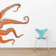 an orange octopus wall decal on a white wall next to a blue chair and wooden floor