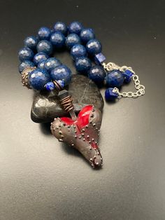 "OOAK artisan made armored glass heart pendant with huge faceted lapis round gemstones hand knotted necklace.  This necklace will adjust from 17\" to 20\" and anywhere in between.  The heart pendant hangs down an additional 2 1/2\". So, what can I say about this incredible necklace with an amazing piece of artwork heart pendant?!  Yes, it's true that I LOVE pieces that don't look like everything else out there.  So when I first saw this unbelievable lampwork heart with what looks like armor attached to it I was instantly in love because there have been many times in my own life when I could have used a cloak of armor around my own heart. 😢   I decided to use this incredible pendant with all gorgeous blue lapis hand knotted with sturdy knotting cord.  There is also one armored lampwork lar Knotted Jewelry, Hand Knotted Necklace, Knotted Necklace, Jewelry Knots, Glass Heart, Quality Jewelry, Heart Pendant, Necklace Etsy, Jewelry Necklace Pendant