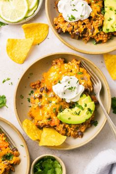 two bowls filled with mexican food and topped with sour cream