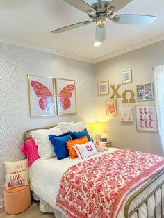 a bedroom with a bed, ceiling fan and pictures on the wall above it's headboard