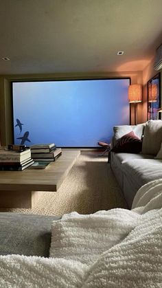 a living room filled with furniture and a large screen