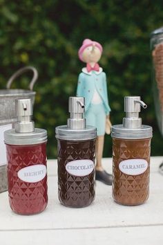 three jars with soap dispensers sitting on a table