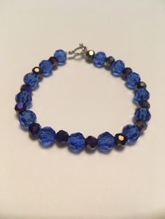 A bracelet with dark blue and dark purple crystals. About 7 1/2 inches Blue Faceted Crystal Bracelets, Dark Purple Crystals, Purple Bracelets, Purple Crystal Bracelet, Purple Bracelet, Purple Crystal, A Bracelet, Purple Crystals, Crystal Bracelet