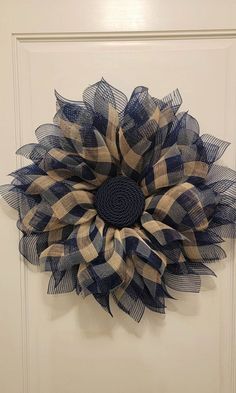 a large blue and white flower hanging on the front door