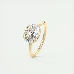 a yellow gold engagement ring with a round cut diamond in the center, on a white background